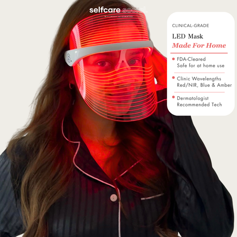 A woman wearing a red LED light therapy face mask with a clear shield visor, shown against a light gray background with a product information panel on the right. The brand name 'selfcare social' is visible at the top.